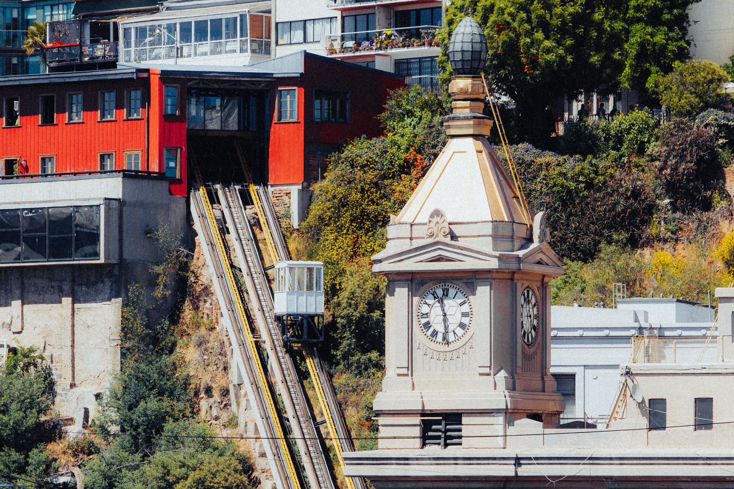 A vibrant view of Valparaíso's funicular railway and historic clock tower on a sunny day.